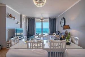 a dining room with a table and chairs and the ocean at Apartment 7 on Paul do Mar Beach in Paul do Mar