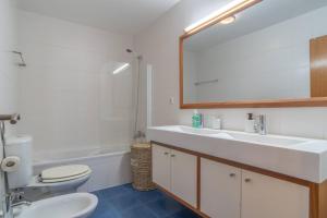 a bathroom with a sink and a toilet and a mirror at Apartment 7 on Paul do Mar Beach in Paul do Mar +9 photos