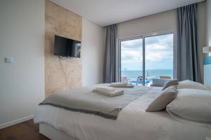 a bedroom with a large bed with a view of the ocean at Villa Azinhaga in Gaula +30 photos