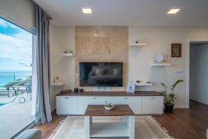 a living room with a tv and a large window at Villa Azinhaga in Gaula