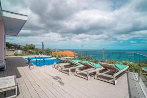 a deck with lounge chairs and a swimming pool at Villa Azinhaga in Gaula