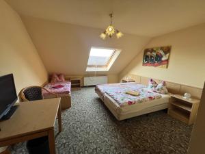 a bedroom with a bed and a desk and a tv at Pension Serbitzer Hof in Serbitz