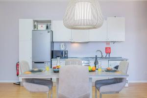 a kitchen with a table with chairs and a pendant light at Old Town T1 Apartment in Funchal