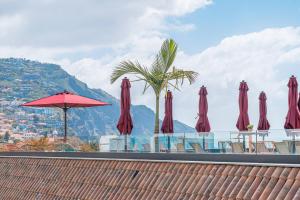 a group of red umbrellas sitting on top of a table at Old Town T1 Apartment in Funchal