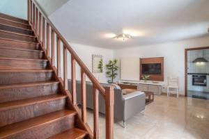 a living room with a staircase and a couch at Villa Alegra Paul do Mar in Paul do Mar