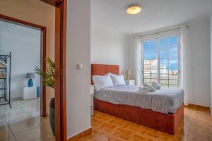 a bedroom with a bed and a large window at Villa Alegra Paul do Mar in Paul do Mar