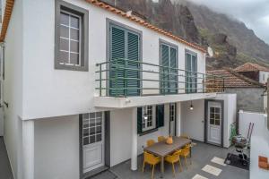 a house with a balcony with a table and chairs at Villa Alegra Paul do Mar in Paul do Mar