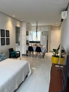 a room with a bed and a dining room and a kitchen at Itapuã Beach - Espaço Aconchegante e Tranquilo pra você e sua família! in Salvador