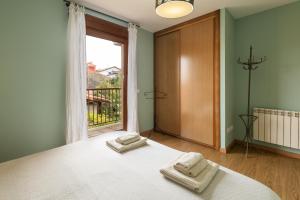 a bedroom with a bed with two towels on it at Casa Llanes (Poo) cerca de la playa - Traudel in Llanes