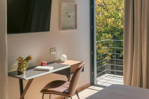 a desk with a chair next to a window at Nõs Luxury Rooms in Missolonghi