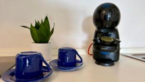 a blender and two blue cups on a counter at apartament skyline park residense in Lignano Sabbiadoro