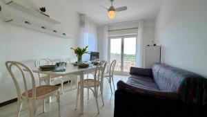 a living room with a table and chairs and a refrigerator at apartament skyline park residense in Lignano Sabbiadoro