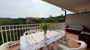a table with a vase of flowers on a balcony at apartament skyline park residense in Lignano Sabbiadoro