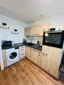 a kitchen with wooden cabinets and a washer and dryer at Ferienwohnung Nelli in Sankt Englmar