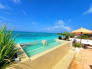 a swimming pool with the beach in the background at Aluna Beach House Nungwi in Nungwi