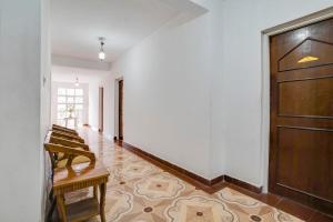 a hallway with a wooden door and a wooden bench at Super Collection O Calangute in Goa