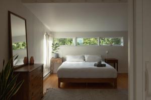 a bedroom with a bed and a large window at The Beach Barn & Cedar Sauna in Kingsburg