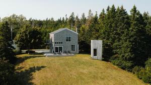 a house on top of a field with trees at The Beach Barn & Cedar Sauna in Kingsburg