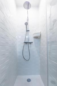 a white bathroom with a shower with a shower head at La maison de Vallières in Clermont-Ferrand +18 photos
