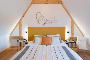 a bedroom with a large bed with two chairs at Écodomaine le Vérin, Gîtes et spa - Mer, Nature & Confort - Côte d'Opale in Wierre-Effroy +43 photos