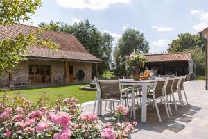 a patio with a table and chairs in a garden at Casiola - Authentic Serene Vacation Hideaway with Pond in Harelbeke