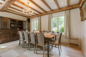 a dining room with a wooden table and chairs at Casiola - Authentic Serene Vacation Hideaway with Pond in Harelbeke