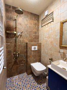 a bathroom with a shower and a toilet and a sink at Hotel Commune 1889 in Kutaisi