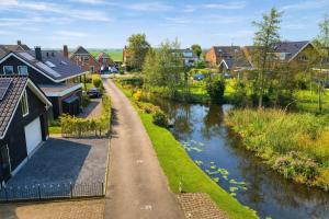 a village with a river and houses and a road at Cetti's Lodge - met privé sauna in Nieuwkoop