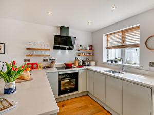a white kitchen with a sink and a stove at 2 Bed in Helmsley oc-g0037 in Helmsley