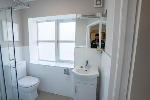 a bathroom with a sink and a toilet and a window at Alensgrove Maisonette A in Leixlip +46 photos