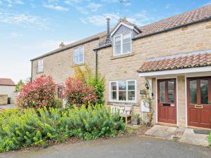 a brick house with a bench in front of it at 2 Bed in Helmsley oc-g0037 in Helmsley