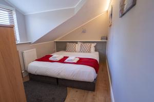 a bedroom with a bed with a red blanket at Alensgrove Maisonette A in Leixlip