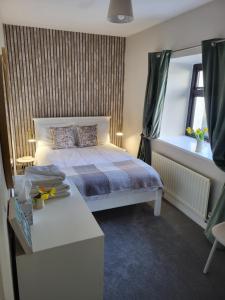 a bedroom with a bed and a window at Rose Meadow Cottage in Liscannor