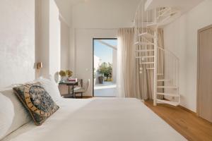 a bedroom with a white bed and a spiral staircase at Nõs Luxury Rooms in Missolonghi +68 photos