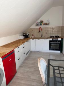 a kitchen with white cabinets and a red refrigerator at Im Herzen des Elbsandsteingebirges in Königstein an der Elbe