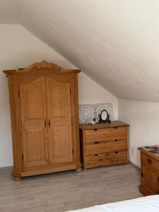 a bedroom with a wooden cabinet and a dresser at Im Herzen des Elbsandsteingebirges in Königstein an der Elbe