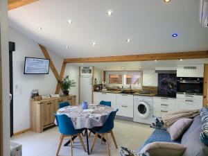 a kitchen and living room with a table and blue chairs at - - - - -Les Colombages - - - - Chambre d'hôtes-Gîte- Classement Gîte 3 étoiles in Mirepoix