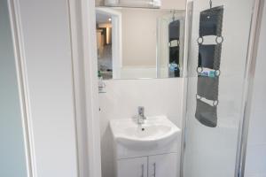 a white bathroom with a sink and a mirror at Alensgrove Maisonette B in Leixlip +40 photos