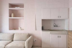 a white living room with a couch and a kitchen at Winahost La Llar del Mar in San Pol de Mar