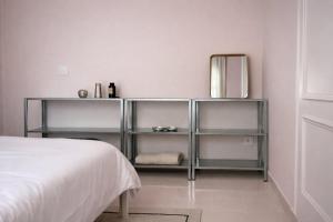 a white bedroom with a bed and a mirror at Winahost La Llar del Mar in San Pol de Mar