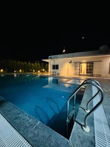 a swimming pool in front of a house at night at Courtyard Villa in Bhopal