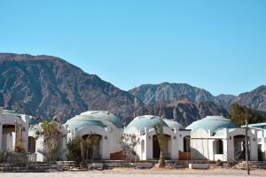 a building in the desert with mountains in the background at Dana beach camp in Nuweiba