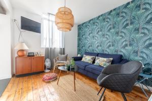 a living room with a blue couch and a table at La maison de Vallières in Clermont-Ferrand