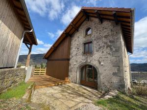 a building with a wooden door and a wooden deck at Gîte d'Eléonore in Rupt-sur-Moselle
