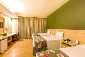 a hotel room with two beds and a desk at Tauá Hotel & Convention Atibaia in Bairro Rio Abaixo +56 photos