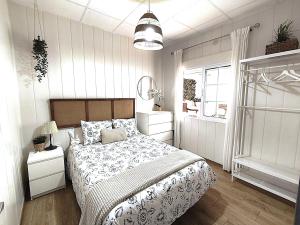 a white bedroom with a bed and a window at Casa tradicional Torrevieja in Torrevieja