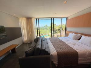 a hotel room with a large bed and a couch at Hotel Boutique Vila don Patto in São Roque