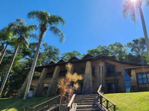 an exterior view of a building with palm trees at Hotel Boutique Vila don Patto in São Roque