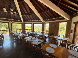 a restaurant with wooden tables and chairs and windows at Hotel Boutique Vila don Patto in São Roque
