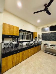 a large kitchen with wooden cabinets and a ceiling fan at Courtyard Villa in Bhopal